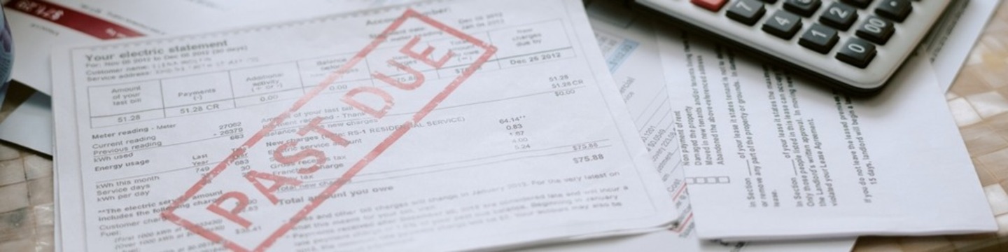 Overdue bills on a desk with a calculator